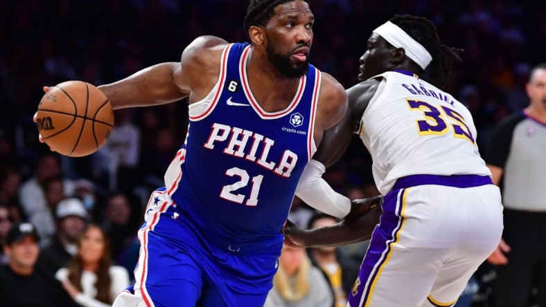 Jan 15, 2023; Los Angeles, California, USA; Philadelphia 76ers center Joel Embiid (21) moves the ball against Los Angeles Lakers forward Wenyen Gabriel (35) during the first half at Crypto.com Arena. Mandatory Credit: Gary A. Vasquez-USA TODAY Sports