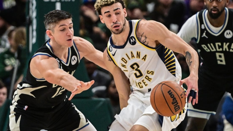 Jan 16, 2023; Milwaukee, Wisconsin, USA; Milwaukee Bucks guard Grayson Allen (12) tries to steal ball from Indiana Pacers guard Chris Duarte (3) in the second quarter at Fiserv Forum. Mandatory Credit: Benny Sieu-USA TODAY Sports