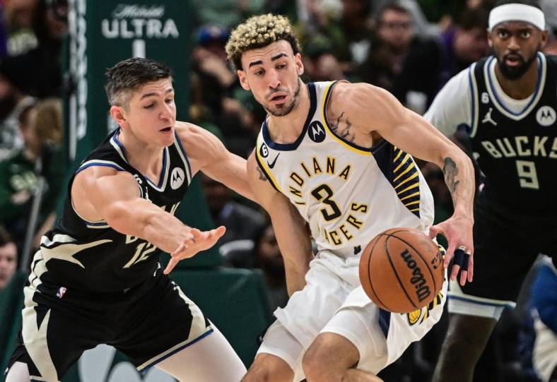 Jan 16, 2023; Milwaukee, Wisconsin, USA; Milwaukee Bucks guard Grayson Allen (12) tries to steal ball from Indiana Pacers guard Chris Duarte (3) in the second quarter at Fiserv Forum. Mandatory Credit: Benny Sieu-USA TODAY Sports