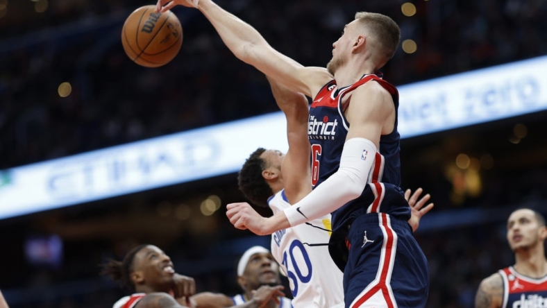 Jan 16, 2023; Washington, District of Columbia, USA; Washington Wizards center Kristaps Porzingis (6) blocks the shot of Golden State Warriors guard Stephen Curry (30) in the first quarter at Capital One Arena. Mandatory Credit: Geoff Burke-USA TODAY Sports