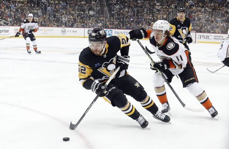 Jan 16, 2023; Pittsburgh, Pennsylvania, USA;  Pittsburgh Penguins defenseman Mark Friedman (52) moves the puck ahead of Anaheim Ducks center Trevor Zegras (11) during the first period  at PPG Paints Arena. Mandatory Credit: Charles LeClaire-USA TODAY Sports