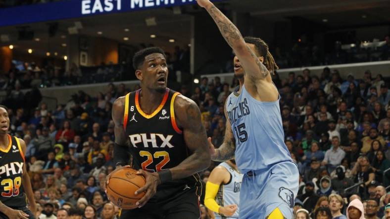 Jan 16, 2023; Memphis, Tennessee, USA; Phoenix Suns center Deandre Ayton (22) spins toward the basket as Memphis Grizzlies forward Brandon Clark (15) defends during the second half at FedExForum. Mandatory Credit: Petre Thomas-USA TODAY Sports