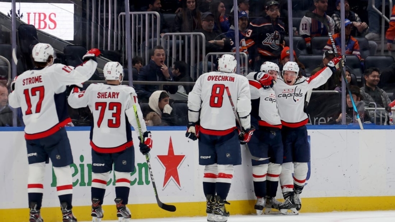 Jan 16, 2023; Elmont, New York, USA; Washington Capitals defenseman Dmitry Orlov (9) celebrates his game winning goal against the New York Islanders with teammates during overtime at UBS Arena. Mandatory Credit: Brad Penner-USA TODAY Sports