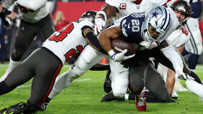 Jan 16, 2023; Tampa, Florida, USA; Dallas Cowboys running back Tony Pollard (20) rushes the ball against Tampa Bay Buccaneers safety Mike Edwards (32) in the first half during the wild card game at Raymond James Stadium. Mandatory Credit: Kim Klement-USA TODAY Sports
