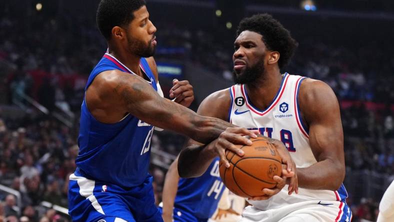 Jan 17, 2023; Los Angeles, California, USA; Philadelphia 76ers center Joel Embiid (21) is fouled by LA Clippers guard Paul George (13) in the first half at Crypto.com Arena. Mandatory Credit: Kirby Lee-USA TODAY Sports