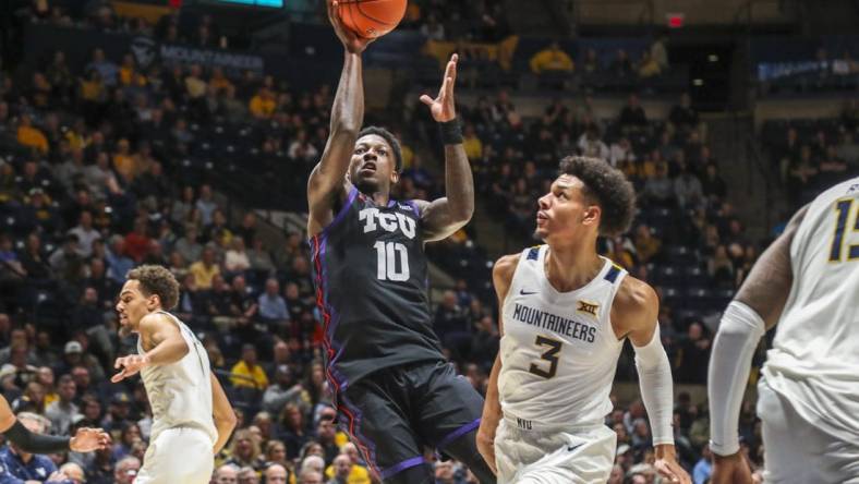 Jan 18, 2023; Morgantown, West Virginia, USA; TCU Horned Frogs guard Damion Baugh (10) shoots in the lane against West Virginia Mountaineers forward Tre Mitchell (3) during the first half at WVU Coliseum. Mandatory Credit: Ben Queen-USA TODAY Sports