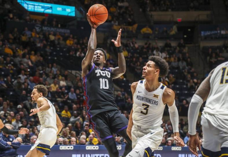 Jan 18, 2023; Morgantown, West Virginia, USA; TCU Horned Frogs guard Damion Baugh (10) shoots in the lane against West Virginia Mountaineers forward Tre Mitchell (3) during the first half at WVU Coliseum. Mandatory Credit: Ben Queen-USA TODAY Sports