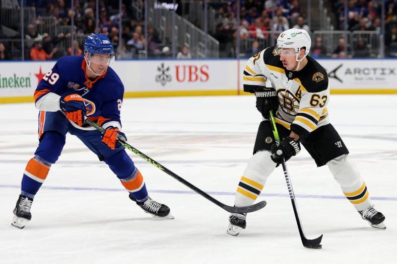 Jan 18, 2023; Elmont, New York, USA; Boston Bruins left wing Brad Marchand (63) controls the puck against New York Islanders center Brock Nelson (29) during the first period at UBS Arena. Mandatory Credit: Brad Penner-USA TODAY Sports