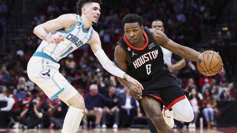 Jan 18, 2023; Houston, Texas, USA;  Houston Rockets forward Jae'Sean Tate (8) drives with the ball as Charlotte Hornets guard LaMelo Ball (1) defends during the second quarter at Toyota Center. Mandatory Credit: Troy Taormina-USA TODAY Sports