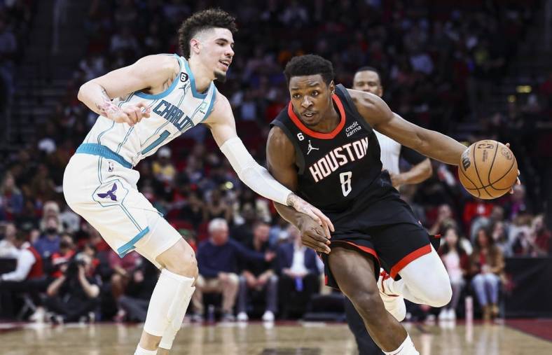 Jan 18, 2023; Houston, Texas, USA;  Houston Rockets forward Jae'Sean Tate (8) drives with the ball as Charlotte Hornets guard LaMelo Ball (1) defends during the second quarter at Toyota Center. Mandatory Credit: Troy Taormina-USA TODAY Sports