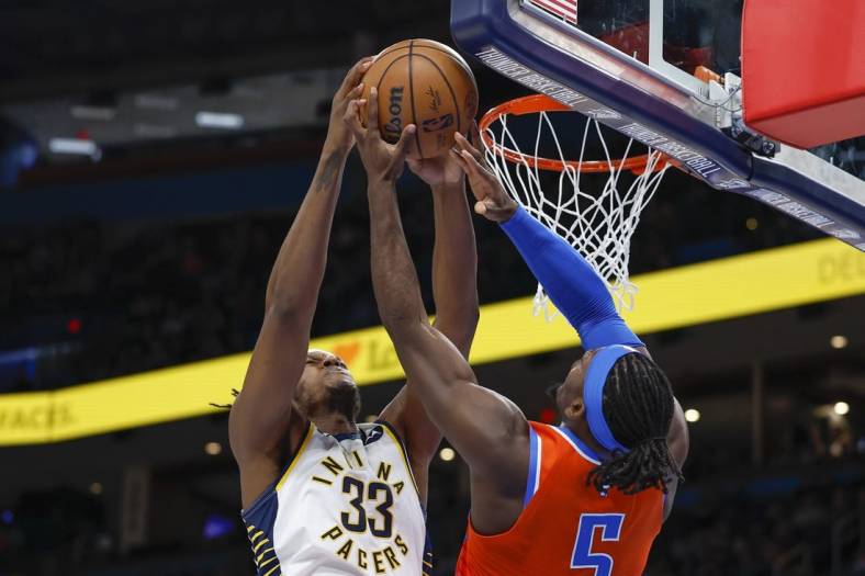 Jan 18, 2023; Oklahoma City, Oklahoma, USA; Indiana Pacers center Myles Turner (33) and Oklahoma City Thunder guard Luguentz Dort (5) fight for a rebound during the second quarter at Paycom Center. Mandatory Credit: Alonzo Adams-USA TODAY Sports