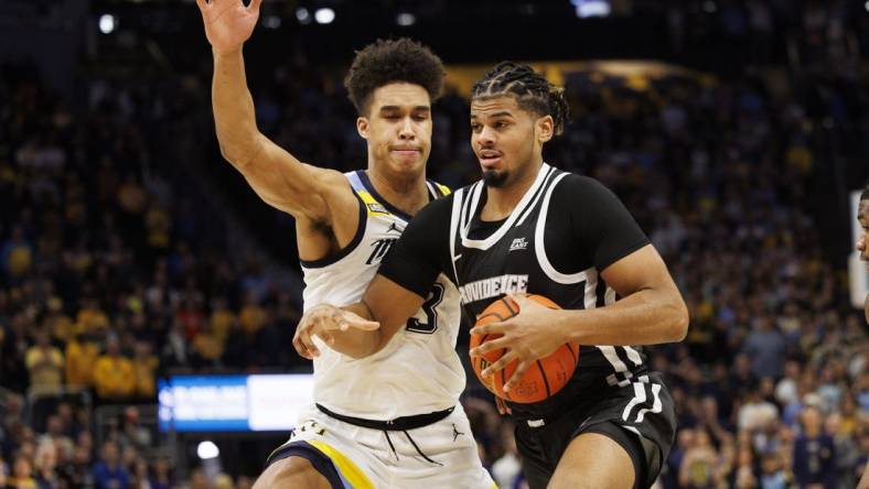 Jan 18, 2023; Milwaukee, Wisconsin, USA;  Providence Friars forward Bryce Hopkins (23) drives for the basket against Marquette Golden Eagles forward Oso Ighodaro (13) during the first half at Fiserv Forum. Mandatory Credit: Jeff Hanisch-USA TODAY Sports