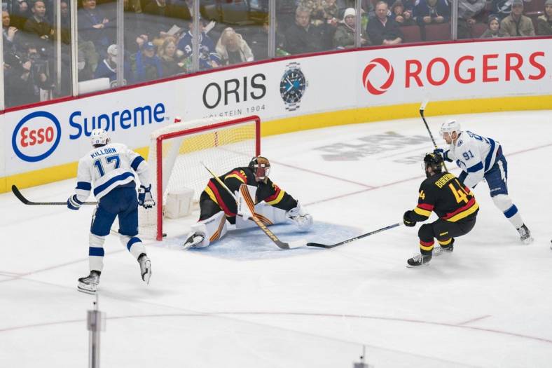 Jan 18, 2023; Vancouver, British Columbia, CAN; Tampa Bay Lightning forward Alex Killorn (17) watches as forward Steven Stamkos (91) scores his 500th career NHL goal on Vancouver Canucks goalie Spencer Martin (30) while defenseman Kyle Burroughs (44) looks on in the first period at Rogers Arena. Mandatory Credit: Bob Frid-USA TODAY Sports