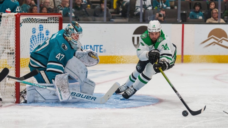 Jan 18, 2023; San Jose, California, USA; Dallas Stars left wing Jamie Benn (14) attempt to control the puck in front of San Jose Sharks goaltender James Reimer (47) during the first period at SAP Center at San Jose. Mandatory Credit: Neville E. Guard-USA TODAY Sports