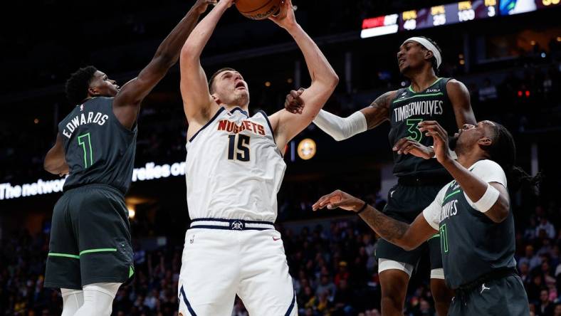 Jan 18, 2023; Denver, Colorado, USA; Denver Nuggets center Nikola Jokic (15) is fouled by Minnesota Timberwolves forward Jaden McDaniels (3) as he battles for a rebound with Minnesota Timberwolves guard Anthony Edwards (1) and center Naz Reid (11) in the second quarter at Ball Arena. Mandatory Credit: Isaiah J. Downing-USA TODAY Sports