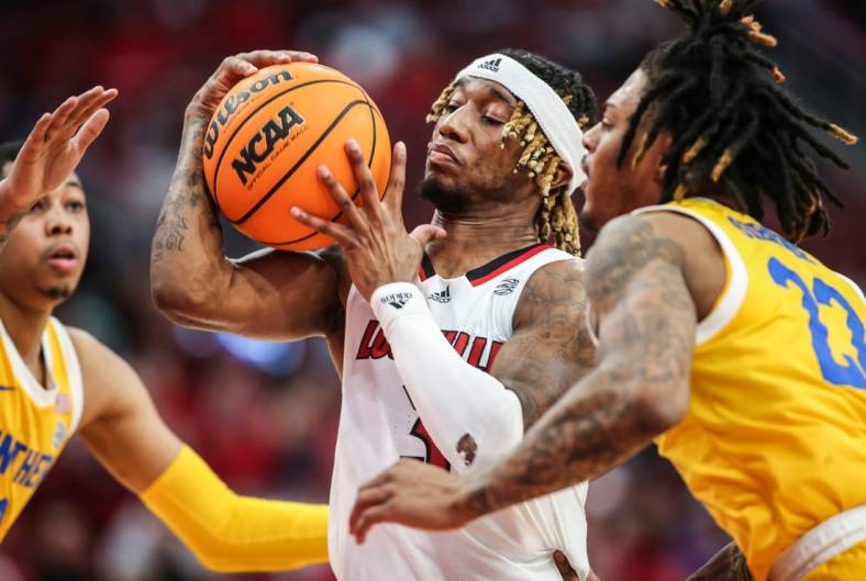 Louisville's El Ellis drives between Pitt guard Greg Elliott, left, and Pitt guard Nike Sibande in the second half. The Cards lost 75-54 to the visiting Panthers.  Jan. 18, 2023

Louisville Vs Pitt Jan 18 2023