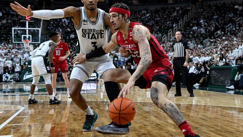 Jan 19, 2023; East Lansing, Michigan, USA; Rutgers Scarlet Knights guard Caleb McConnell (22) drives the baseline against Michigan State Spartans guard Jaden Akins (3) in the first half at Jack Breslin Student Events Center. Mandatory Credit: Dale Young-USA TODAY Sports