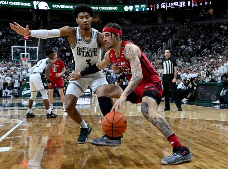Jan 19, 2023; East Lansing, Michigan, USA; Rutgers Scarlet Knights guard Caleb McConnell (22) drives the baseline against Michigan State Spartans guard Jaden Akins (3) in the first half at Jack Breslin Student Events Center. Mandatory Credit: Dale Young-USA TODAY Sports