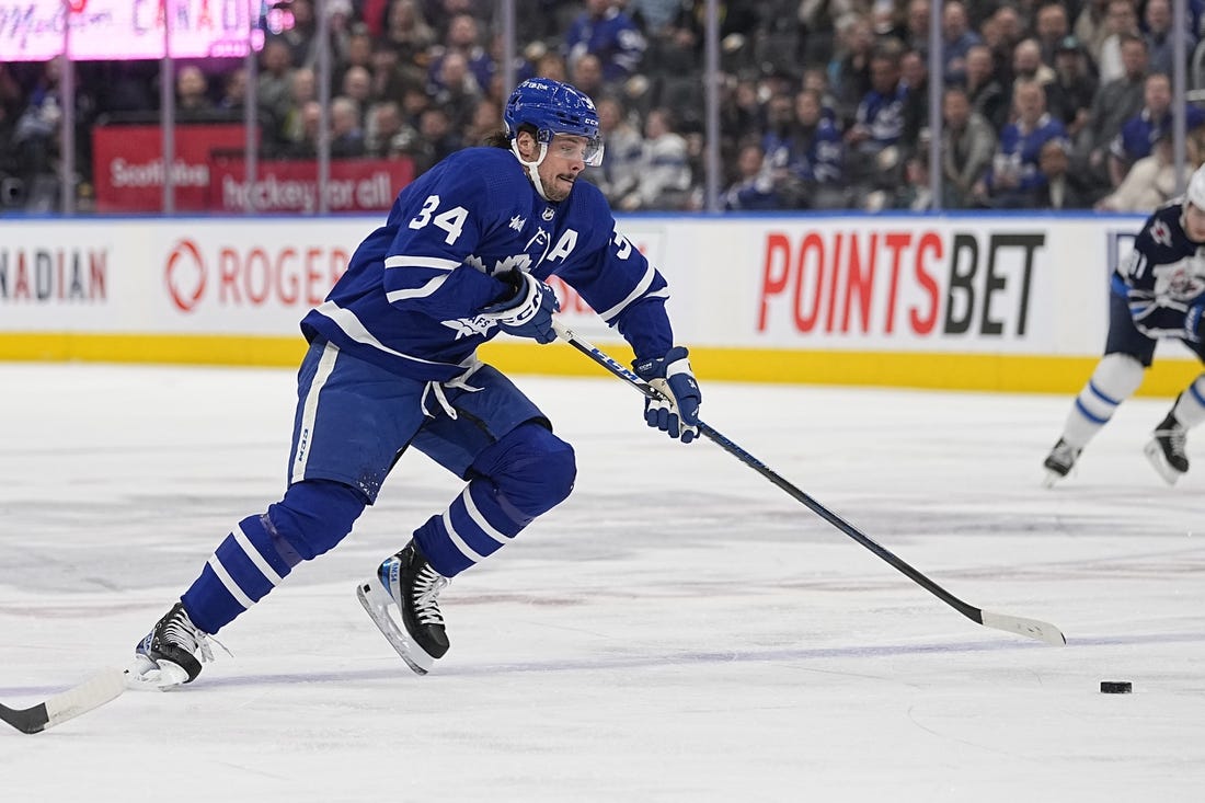 Jan 19, 2023; Toronto, Ontario, CAN; Toronto Maple Leafs forward Auston Matthews (34) tries to get control of a puck against the Winnipeg Jets during the first period at Scotiabank Arena. Mandatory Credit: John E. Sokolowski-USA TODAY Sports