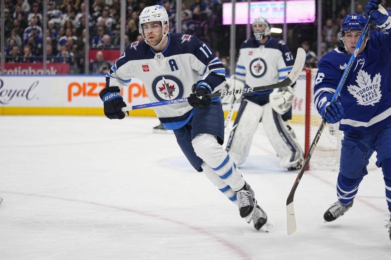 Jan 19, 2023; Toronto, Ontario, CAN; Winnipeg Jets forward Adam Lowry (17) skates past Toronto Maple Leafs forward Mitchell Marner (16) during the first period at Scotiabank Arena. Mandatory Credit: John E. Sokolowski-USA TODAY Sports
