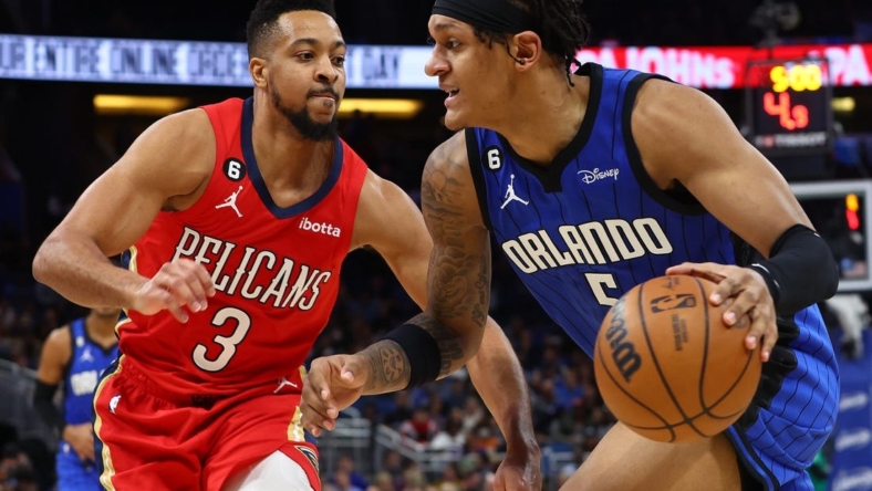 Jan 20, 2023; Orlando, Florida, USA; Orlando Magic forward Paolo Banchero (5) drives to the basket as New Orleans Pelicans guard CJ McCollum (3) defends during the second quarter at Amway Center. Mandatory Credit: Kim Klement-USA TODAY Sports