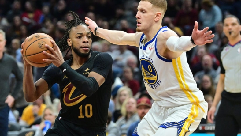 Jan 20, 2023; Cleveland, Ohio, USA; Cleveland Cavaliers guard Darius Garland (10) drives to the basket against Golden State Warriors guard Donte DiVincenzo (0) during the second half at Rocket Mortgage FieldHouse. Mandatory Credit: Ken Blaze-USA TODAY Sports