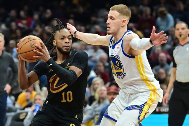 Jan 20, 2023; Cleveland, Ohio, USA; Cleveland Cavaliers guard Darius Garland (10) drives to the basket against Golden State Warriors guard Donte DiVincenzo (0) during the second half at Rocket Mortgage FieldHouse. Mandatory Credit: Ken Blaze-USA TODAY Sports