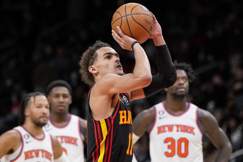 Jan 20, 2023; Atlanta, Georgia, USA; Atlanta Hawks guard Trae Young (11) shoots a foul shot watched by New York Knicks players after a technical foul call during the second half at State Farm Arena. Mandatory Credit: Dale Zanine-USA TODAY Sports
