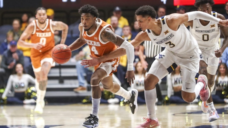 Jan 21, 2023; Morgantown, West Virginia, USA; Texas Longhorns guard Tyrese Hunter (4) steals a pass as West Virginia Mountaineers forward Tre Mitchell (3) defends during the first half at WVU Coliseum. Mandatory Credit: Ben Queen-USA TODAY Sports