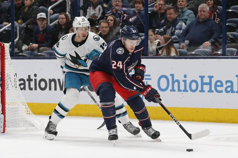 Jan 21, 2023; Columbus, Ohio, USA; Columbus Blue Jackets center Mathieu Olivier (24) grabs a loose puck as San Jose Sharks center Nick Bonino (13) trails the play during the first period at Nationwide Arena. Mandatory Credit: Russell LaBounty-USA TODAY Sports