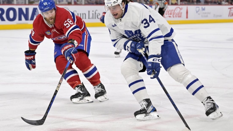 Jan 21, 2023; Montreal, Quebec, CAN; Toronto Maple Leafs forward Auston Matthews (34) plays the puck as Montreal Canadiens defenseman David Savard (58) defends during the first period at the Bell Centre. Mandatory Credit: Eric Bolte-USA TODAY Sports