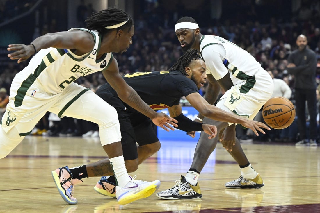Jan 21, 2023; Cleveland, Ohio, USA; Cleveland Cavaliers guard Darius Garland (10) dribbles between Milwaukee Bucks guard Jrue Holiday (21) and forward Bobby Portis (9) in the second quarter at Rocket Mortgage FieldHouse. Mandatory Credit: David Richard-USA TODAY Sports