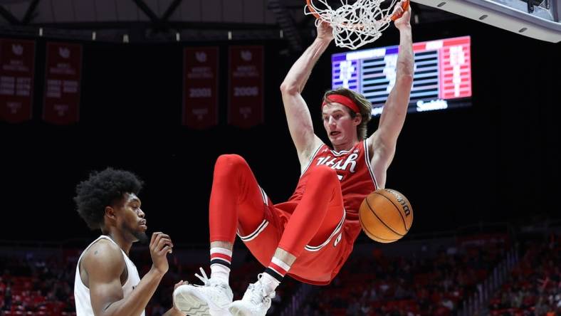 Jan 21, 2023; Salt Lake City, Utah, USA; Utah Utes center Branden Carlson (right) dunks against Washington Huskies forward Keion Brooks (left) in the second half at Jon M. Huntsman Center. Mandatory Credit: Rob Gray-USA TODAY Sports