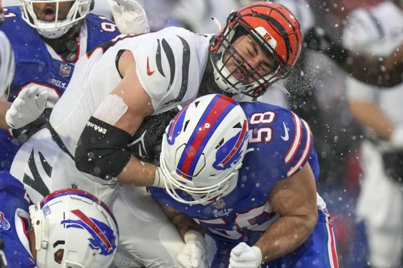 Jan 22, 2023; Orchard Park, New York, USA; Cincinnati Bengals tight end Mitchell Wilcox (84) collides with Buffalo Bills linebacker Matt Milano (58) after a catch in the second quarter of the NFL divisional playoff football game between the Cincinnati Bengals and the Buffalo Bills during an AFC divisional round game at Highmark Stadium. Mandatory Credit: Sam Greene-USA TODAY Sports