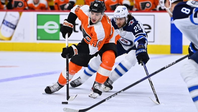 Jan 22, 2023; Philadelphia, Pennsylvania, USA; Philadelphia Flyers center Morgan Frost (48) reaches for the puck against Winnipeg Jets center Kevin Stenlund (28) in the second period at Wells Fargo Center. Mandatory Credit: Kyle Ross-USA TODAY Sports