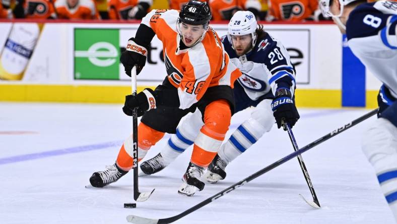 Jan 22, 2023; Philadelphia, Pennsylvania, USA; Philadelphia Flyers center Morgan Frost (48) reaches for the puck against Winnipeg Jets center Kevin Stenlund (28) in the second period at Wells Fargo Center. Mandatory Credit: Kyle Ross-USA TODAY Sports