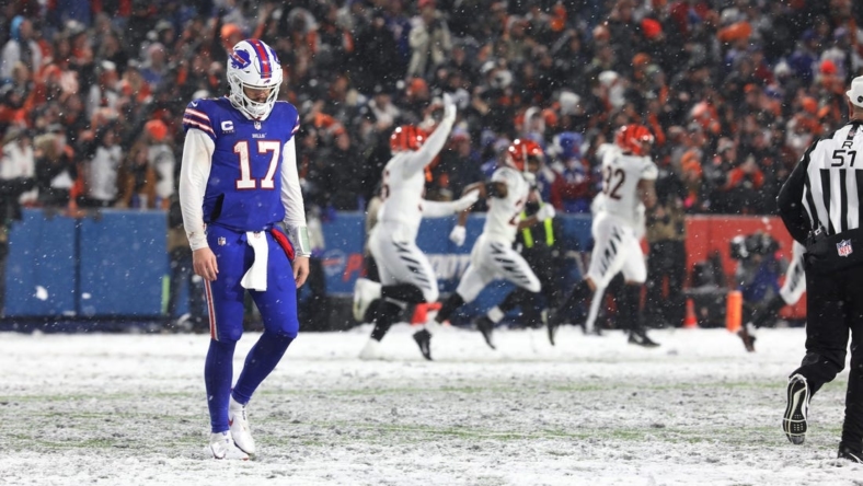 Bills quarterback Josh Allen walks off the field after throwing an interception late in the fourth quarter at Highmark Stadium in Orchard Park on Jan. 22  In the background the Cincinnati Bengals players celebrate.

Ty 012223 Dejected Josh Allen After Fourth Quarter Interception