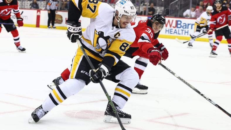 Jan 22, 2023; Newark, New Jersey, USA; Pittsburgh Penguins center Sidney Crosby (87) skates with the puck while being defended by New Jersey Devils defenseman Ryan Graves (33) during the third period at Prudential Center. Mandatory Credit: Ed Mulholland-USA TODAY Sports