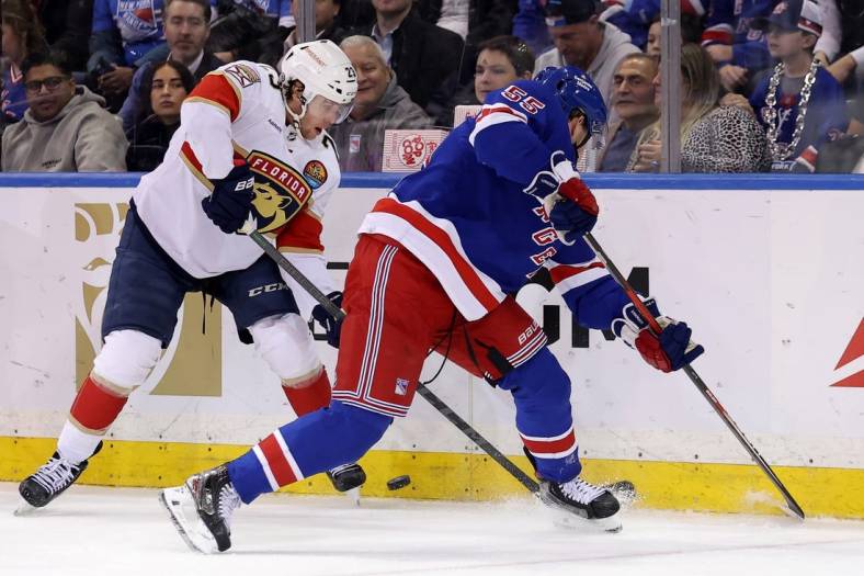 Jan 23, 2023; New York, New York, USA; Florida Panthers center Carter Verhaeghe (23) fights for the puck against New York Rangers defenseman Ryan Lindgren (55) during the second period at Madison Square Garden. Mandatory Credit: Brad Penner-USA TODAY Sports