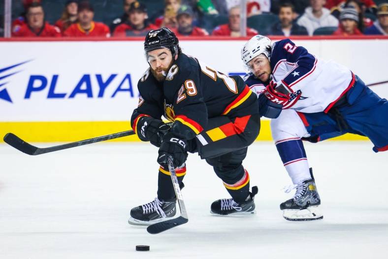 Jan 23, 2023; Calgary, Alberta, CAN; Calgary Flames center Dillon Dube (29) and Columbus Blue Jackets defenseman Andrew Peeke (2) battle for the puck during the second period at Scotiabank Saddledome. Mandatory Credit: Sergei Belski-USA TODAY Sports