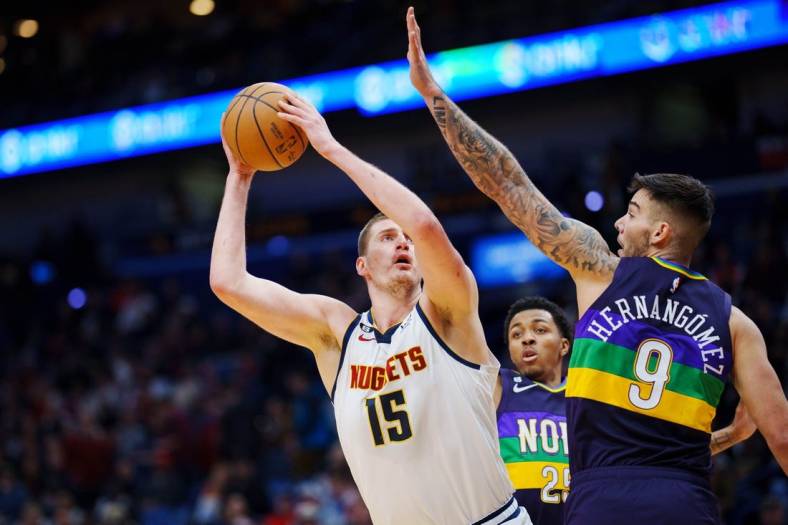 Jan 24, 2023; New Orleans, Louisiana, USA; Denver Nuggets center Nikola Jokic (15) shoots the ball against New Orleans Pelicans center Willy Hernangomez (9) during the first quarter at Smoothie King Center. Mandatory Credit: Andrew Wevers-USA TODAY Sports