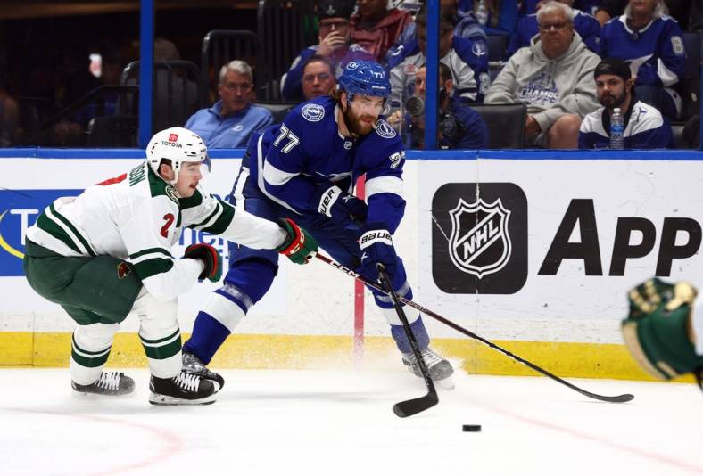 Jan 24, 2023; Tampa, Florida, USA; Tampa Bay Lightning defenseman Victor Hedman (77) skates with the puck as Minnesota Wild defenseman Calen Addison (2) defends during the first period at Amalie Arena. Mandatory Credit: Kim Klement-USA TODAY Sports