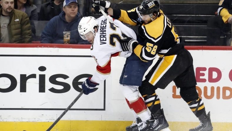 Jan 24, 2023; Pittsburgh, Pennsylvania, USA;  Florida Panthers center Carter Verhaeghe (23) is checked by Pittsburgh Penguins defenseman Kris Letang (58) chases during the second period  at PPG Paints Arena. Mandatory Credit: Charles LeClaire-USA TODAY Sports
