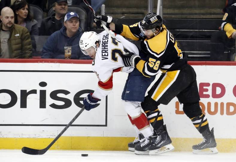 Jan 24, 2023; Pittsburgh, Pennsylvania, USA;  Florida Panthers center Carter Verhaeghe (23) is checked by Pittsburgh Penguins defenseman Kris Letang (58) chases during the second period  at PPG Paints Arena. Mandatory Credit: Charles LeClaire-USA TODAY Sports