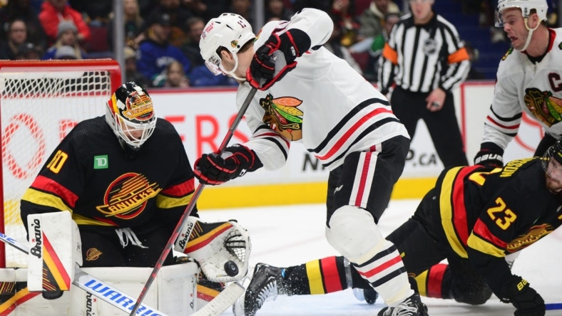 Jan 24, 2023; Vancouver, British Columbia, CAN;  Vancouver Canucks goaltender Collin Delia (60) defends against Chicago Blackhawks forward Taylor Raddysh (11) during the first period at Rogers Arena. Mandatory Credit: Anne-Marie Sorvin-USA TODAY Sports