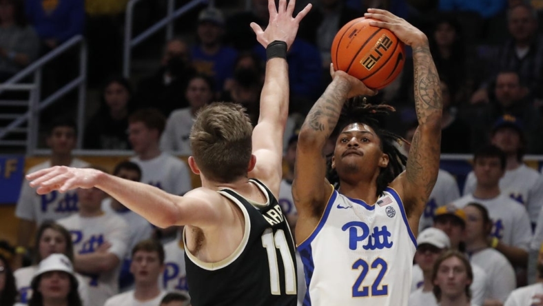 Jan 25, 2023; Pittsburgh, Pennsylvania, USA;  Pittsburgh Panthers guard Nike Sibande (22) shoots a three point basket against Wake Forest Demon Deacons forward Andrew Carr (11) during the first half at the Petersen Events Center. Mandatory Credit: Charles LeClaire-USA TODAY Sports