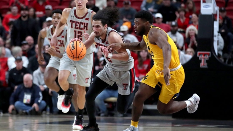 Jan 25, 2023; Lubbock, Texas, USA;  Texas Tech Red Raiders guard Pop Isaacs (2) dribbles against West Virgina Mountaineers guard Seth Wilson (14) in the first half at United Supermarkets Arena. Mandatory Credit: Michael C. Johnson-USA TODAY Sports