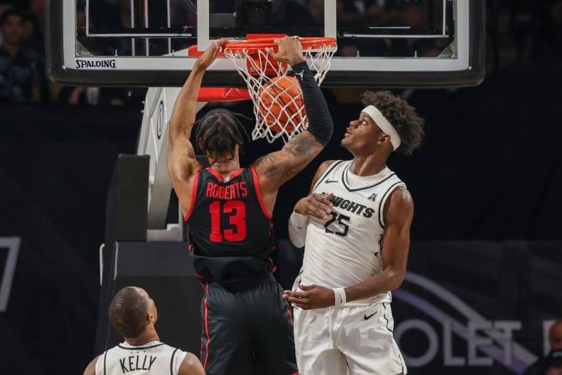 Jan 25, 2023; Orlando, Florida, USA; Houston Cougars forward J'Wan Roberts (13) dunks the ball dunks the ball in front of UCF Knights forward Taylor Hendricks (25) during the first half at Addition Financial Arena. Mandatory Credit: Mike Watters-USA TODAY Sports