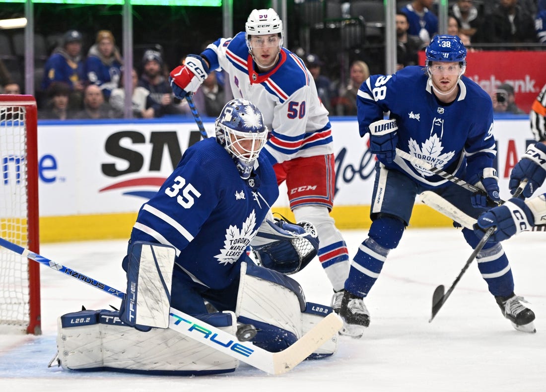 Jan 25, 2023; Toronto, Ontario, CAN;  Toronto Maple Leafs goalie Ilya Samsonov (35) makes a save as defenseman Rasmus Sandin (38) and New York Rangers forward Will Cuyle (50) look for the rebound in the second period at Scotiabank Arena. Mandatory Credit: Dan Hamilton-USA TODAY Sports