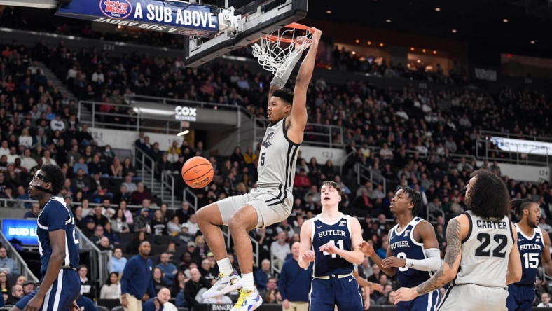 Jan 25, 2023; Providence, Rhode Island, USA; Providence Friars forward Ed Croswell (5) hangs off the basket after dunking against the Butler Bulldogs at Amica Mutual Pavilion. Mandatory Credit: Eric Canha-USA TODAY Sports